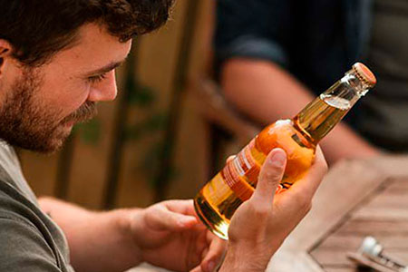 Мужчина читает этикетку бутылки